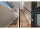 Bright stairway with natural wood stairs, black handrail, and light-filled landing creating an elegant entryway at 1437 Garfield St, Denver, CO 80206