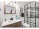 A bathroom features a walk-in shower with glass enclosure, modern vanity, and white tile floors at 15776 E 107Th Way, Commerce City, CO 80022