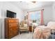 Cozy bedroom with a vintage dresser, accent chair, and natural light at 15776 E 107Th Way, Commerce City, CO 80022