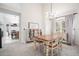 Bright dining room with hardwood table, white chairs and cabinet, and modern chandelier at 15776 E 107Th Way, Commerce City, CO 80022