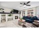 Cozy living room with fireplace, ceiling fan, large windows, and a comfortable blue sofa, perfect for relaxation and entertaining at 15776 E 107Th Way, Commerce City, CO 80022