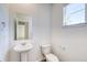 Small bathroom with pedestal sink, toilet and mirror at 23881 E 40Th Ave, Aurora, CO 80019