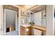 A well-lit bathroom features a vanity with a light wood cabinet, a mirror, and a toilet at 13307 Humboldt Dr, Thornton, CO 80241
