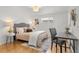 Bright bedroom featuring hardwood floors, a comfortable bed, and a dedicated workspace at 3400 Garland St, Wheat Ridge, CO 80033