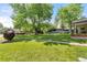 A well-manicured front yard features mature trees and lush green grass at 3400 Garland St, Wheat Ridge, CO 80033