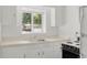 Clean kitchen with stainless steel sink, white countertops, and freshly painted cabinets at 3400 Garland St, Wheat Ridge, CO 80033