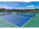 Multiple outdoor pickleball courts with nets and blue and green surface, surrounded by greenery at 1862 Mallard Dr, Superior, CO 80027