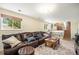 Comfortable living room features a large sofa, wood coffee table, and view of the stairs at 6132 W 113Th Ave, Westminster, CO 80020