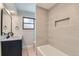Modern bathroom featuring a tub, single vanity, a small window, and tiled accents at 4682 Chatham St, Boulder, CO 80301