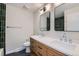 Bathroom featuring double sinks, updated fixtures, and a modern green-tiled shower at 4682 Chatham St, Boulder, CO 80301
