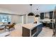 Open concept kitchen with black cabinets, stainless appliances, large marble island, and modern pendant lighting at 4682 Chatham St, Boulder, CO 80301