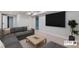 Neutral living room featuring a gray sectional, light wood coffee table, and large screen television at 4682 Chatham St, Boulder, CO 80301