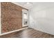 Bedroom with hardwood flooring, exposed brick, and a window with natural light at 3306 N Gilpin St, Denver, CO 80205