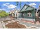 Charming green home with a cozy front porch and landscaped front yard at 3306 N Gilpin St, Denver, CO 80205