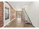 Spacious living room with hardwood floors, exposed brick wall, and a unique metal staircase at 3306 N Gilpin St, Denver, CO 80205