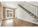 Bright living room with wood floors, a brick accent wall, and modern staircase design at 3306 N Gilpin St, Denver, CO 80205