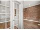 Elegant room with hardwood floors and a brick accent wall visible through glass panel doors at 3306 N Gilpin St, Denver, CO 80205