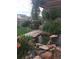 Tranquil backyard oasis with a charming pond, decorative rocks, and a pergola covered in flowering vines at 10153 Pagosa St, Commerce City, CO 80022