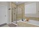 Bathroom featuring tub with tile surround and glass enclosed shower with decorative tiles at 10153 Pagosa St, Commerce City, CO 80022