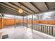 Covered back porch with tiled flooring, wood railing and views of the backyard at 3045 Kearny Street, Denver, CO 80207