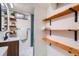 Charming bathroom featuring a modern vanity, floating shelves and shower with stylish blue tile accents at 3045 Kearny Street, Denver, CO 80207