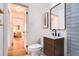 Well-lit bathroom featuring sleek fixtures, tiled shower, and access to hallway at 3045 Kearny Street, Denver, CO 80207