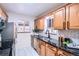 Well-lit kitchen featuring wood cabinets, black countertops, and stainless steel appliances at 3045 Kearny Street, Denver, CO 80207