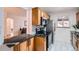 Stylish kitchen featuring wood cabinets, black countertops, stainless steel appliances, and tile floors at 3045 Kearny Street, Denver, CO 80207