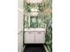 Stylish powder room featuring vibrant wallpaper, modern vanity, and chic herringbone floor at 3957 Utica St, Denver, CO 80212