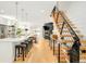 Open-concept living area with kitchen island, modern fireplace, and staircase at 3957 Utica St, Denver, CO 80212