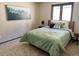 A bedroom with a green patterned bedspread, forest wall art, and neutral walls at 53 Douglas S Dr, Broomfield, CO 80020