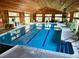 Bright indoor pool area with blue water, marked lanes, wood ceilings, and many plants at 53 Douglas S Dr, Broomfield, CO 80020