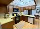 Well-lit kitchen featuring black appliances, wood cabinetry, and an adjacent dining area at 53 Douglas S Dr, Broomfield, CO 80020