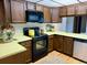 Functional kitchen features a black range, overhead microwave, and oak-style cabinets at 53 Douglas S Dr, Broomfield, CO 80020