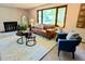 Bright living room with a decorative fireplace, large window, and comfortable seating arrangement at 53 Douglas S Dr, Broomfield, CO 80020