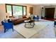 Cozy living room with a leather sofa, blue accent chairs, and large window for natural light at 53 Douglas S Dr, Broomfield, CO 80020