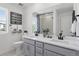 A modern bathroom showing double sinks, gray cabinetry, and a large mirror at 13326 Blue Amber Ct, Parker, CO 80134