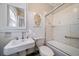 Bathroom with pedestal sink, tub, and tiled shower surround at 2203 Bellaire St, Denver, CO 80207