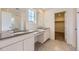 Modern bathroom with double vanity sinks, a large mirror, and a separate room for the toilet and shower at 718 N Clubview St, Watkins, CO 80137