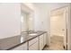 Well-lit bathroom featuring modern vanity with gray countertop, a large mirror and a view of the shower at 718 N Clubview St, Watkins, CO 80137