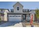 Charming two-story home with a gray exterior, stone accents, attached two-car garage, and landscaped front yard at 718 N Clubview St, Watkins, CO 80137