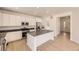 Modern kitchen with white cabinets, stainless steel appliances, a large island, and hardwood floors at 718 N Clubview St, Watkins, CO 80137