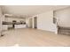 Open-concept living space with hardwood floors seamlessly connecting the living room, kitchen, and staircase at 718 N Clubview St, Watkins, CO 80137