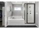 Modern bathroom featuring a soaking tub and glass-enclosed shower with white subway tile at 9406 Bross St, Arvada, CO 80007