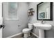 Modern powder room with pedestal sink and stylish fixtures, maximizing a small space at 9406 Bross St, Arvada, CO 80007