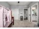Bright bedroom featuring neutral walls, carpet, and access to the ensuite bathroom and hallway at 9406 Bross St, Arvada, CO 80007