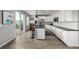 Modern, open kitchen with white cabinets, a large island, stainless steel appliances, and wood flooring at 9406 Bross St, Arvada, CO 80007
