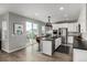Bright kitchen boasts white cabinets, stainless appliances, a central island, and a sliding door to the outside at 9406 Bross St, Arvada, CO 80007
