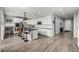 Modern, open kitchen with white cabinets, a large island, stainless steel appliances, and wood flooring at 9406 Bross St, Arvada, CO 80007