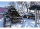 Snow-covered backyard, with a pergola, fountain, and charming wicker furniture, provides a serene winter retreat at 234 S Washington St, Denver, CO 80209